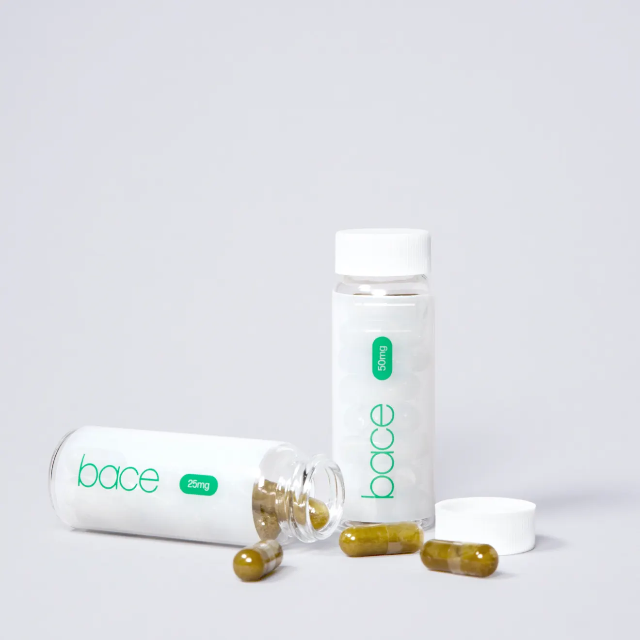 Product photography of two Bace capsule bottles, one open with capsules spilled out
